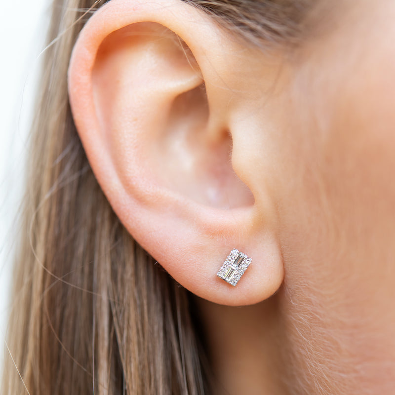 Simple. Modern. Stunning. These beautiful bar-style earrings feature diamond baguettes surrounded by round diamonds that give a beautiful, shimmering look that can be worn day or night.